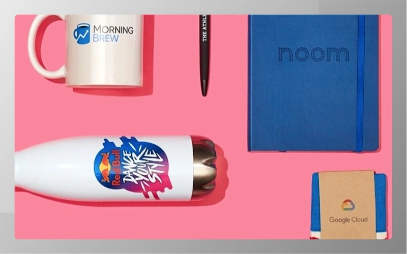 Company branded swag including mugs, water bottles, notebooks, and pens